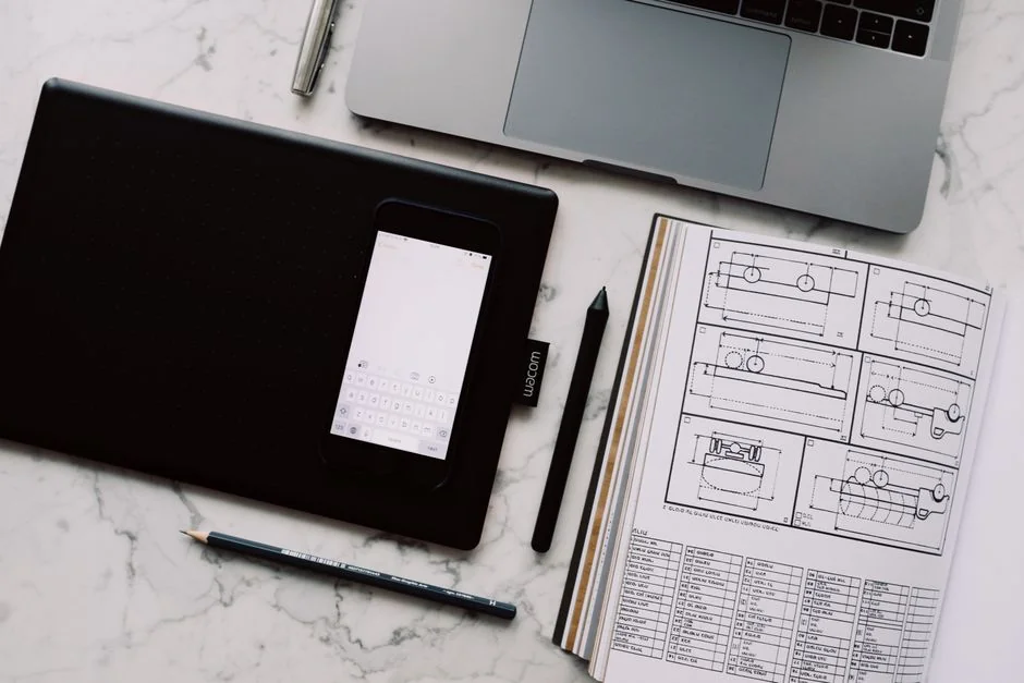 A tidy desk setting with a laptop showing a stock photo website and a smartphone.